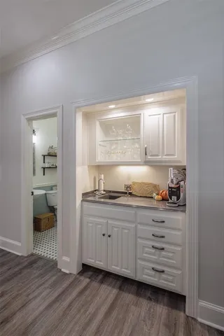 a kitchen with granite countertop white cabinets and wooden floor