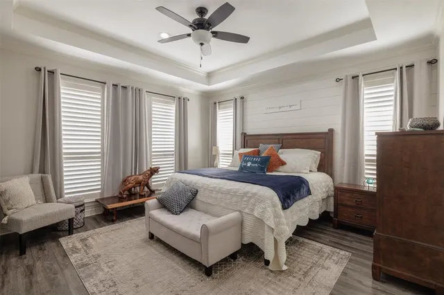 a bedroom with a bed a couch and windows