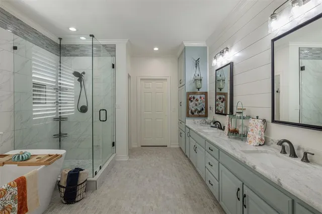 a bathroom with a granite countertop double vanity sink a mirror and shower