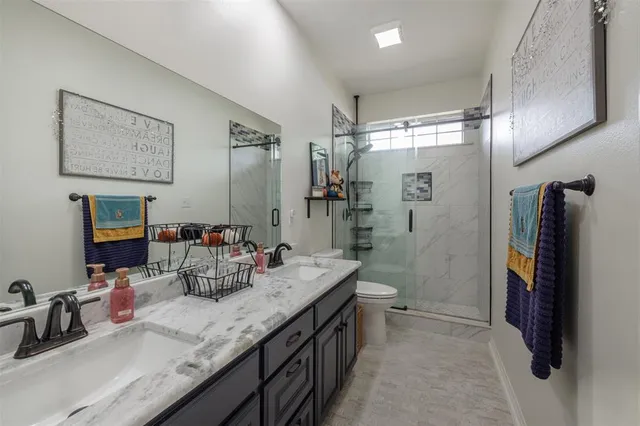 a bathroom with double vanity and a shower