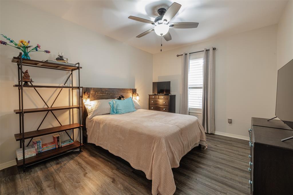106 Graham Lane Bullard, TX 75757 - Photo 24 of 39 a bedroom with a bed a dresser with wooden floor