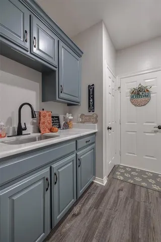a kitchen with a sink cabinets and wooden floor