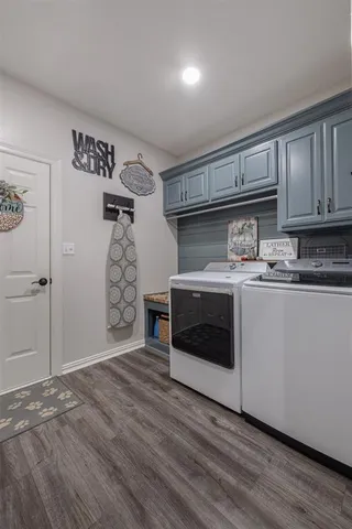 a utility room with cabinets washer and dryer