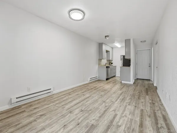 a view of empty room with wooden floor
