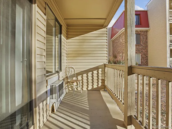 a view of a balcony with wooden floor and fence