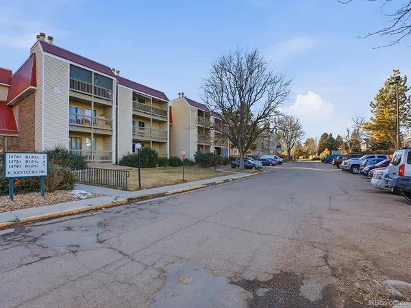a view of building with cars parked in front of it