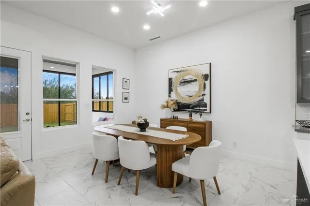 a view of a dining room with furniture and a potted plant