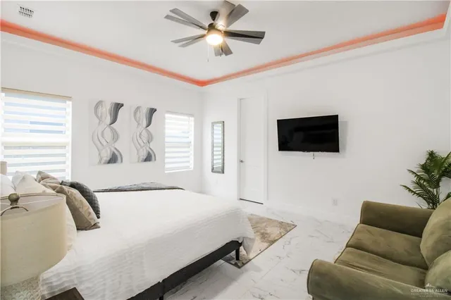 a spacious bedroom with a bed a couch and a flat screen tv