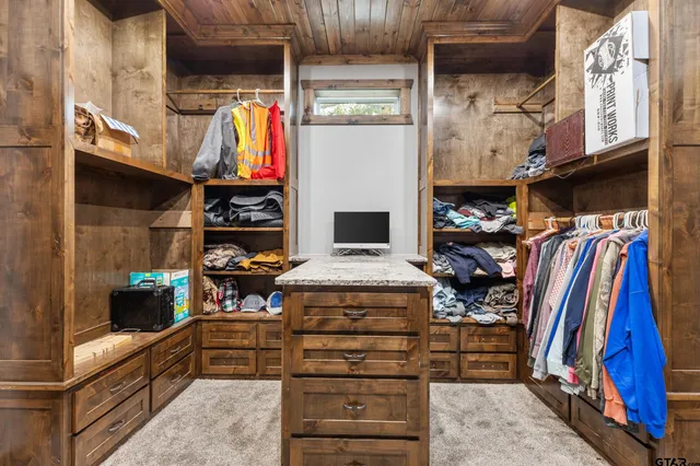 a view of walk in closet with clothes and shoes