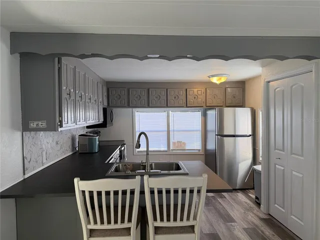 a kitchen with a sink a refrigerator and cabinets