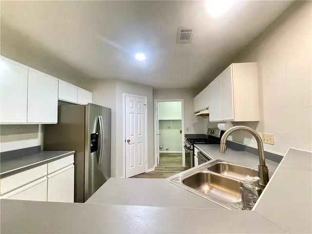 a kitchen with refrigerator and table chair