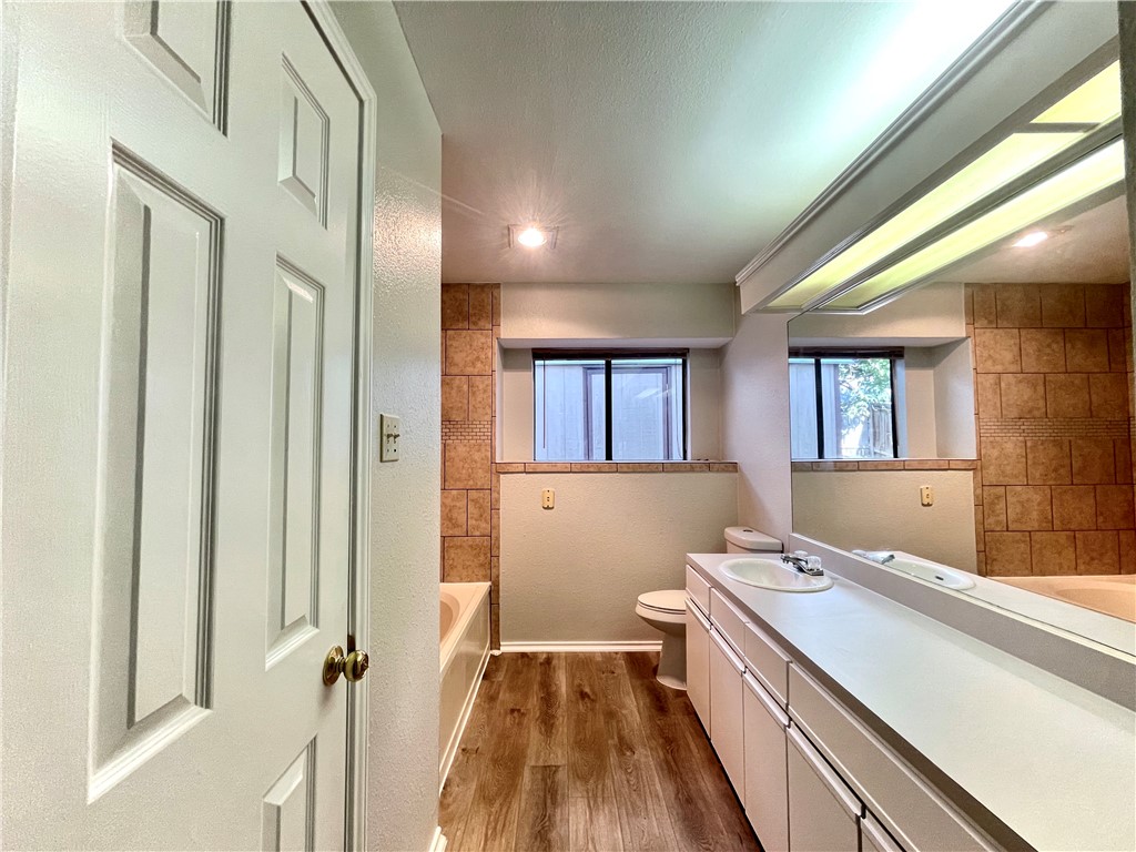 12333 Yarmont Way Austin, TX 78753 - Photo 34 of 40 a spacious bathroom with a granite countertop sink a mirror and a bathtub