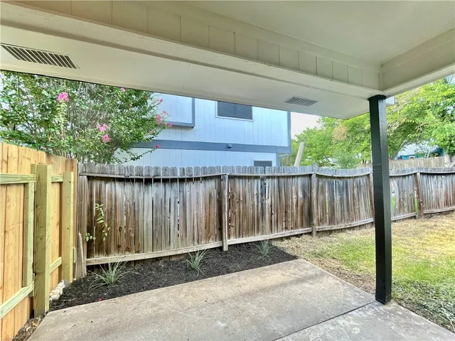 a backyard of a house with a fountain and potted plants