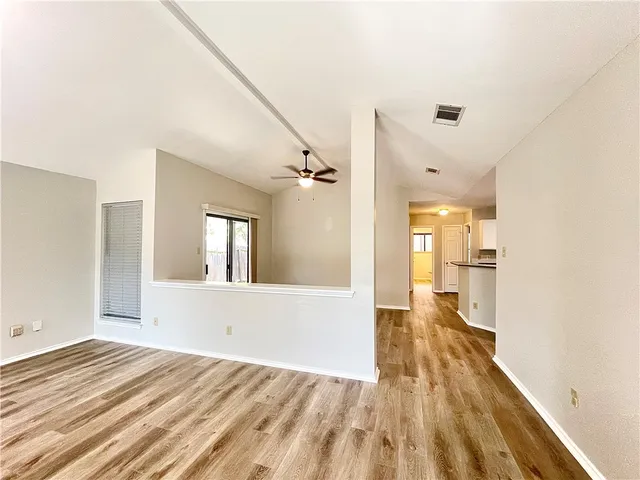 a view of a big room with wooden floor and windows