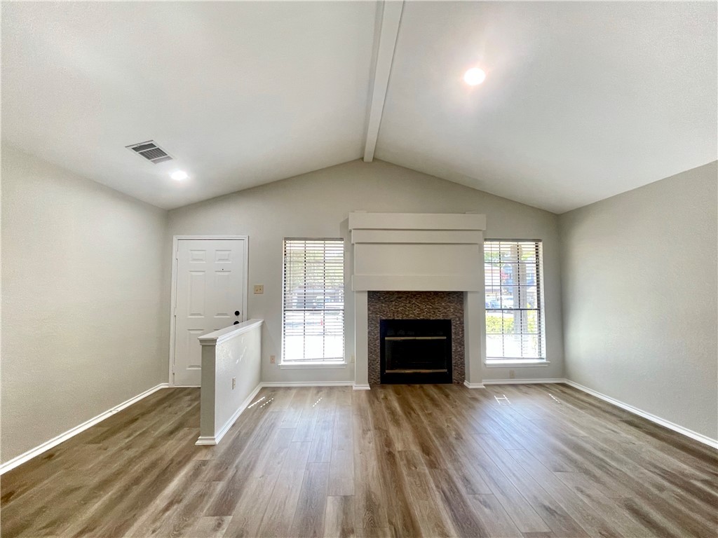 12333 Yarmont Way Austin, TX 78753 - Photo 10 of 40 an empty room with wooden floor fireplace and windows