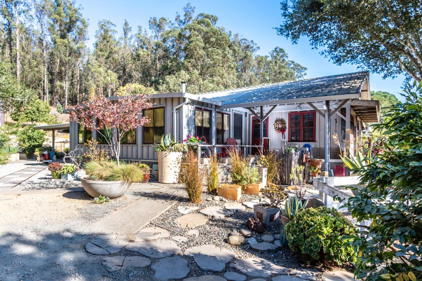 14520 Ridgecrest Road Watsonville, CA 95076 - Photo 1 of 49 a view of a patio with couches table and chairs under an umbrella with large trees