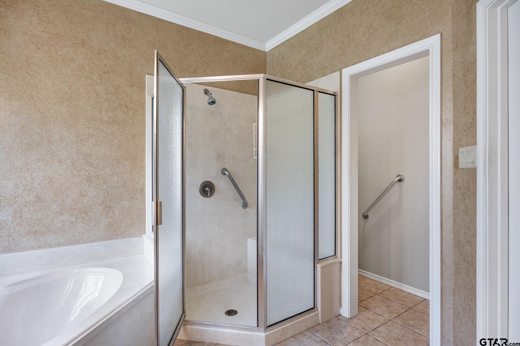 5603 Thomas Nelson Drive Tyler, TX 75707 - Photo 14 of 28 a bathroom with a glass shower door and a bathtub