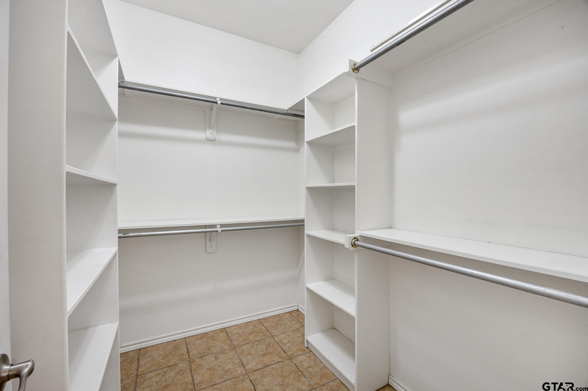 5603 Thomas Nelson Drive Tyler, TX 75707 - Photo 16 of 28 a view of walk in closet with empty racks