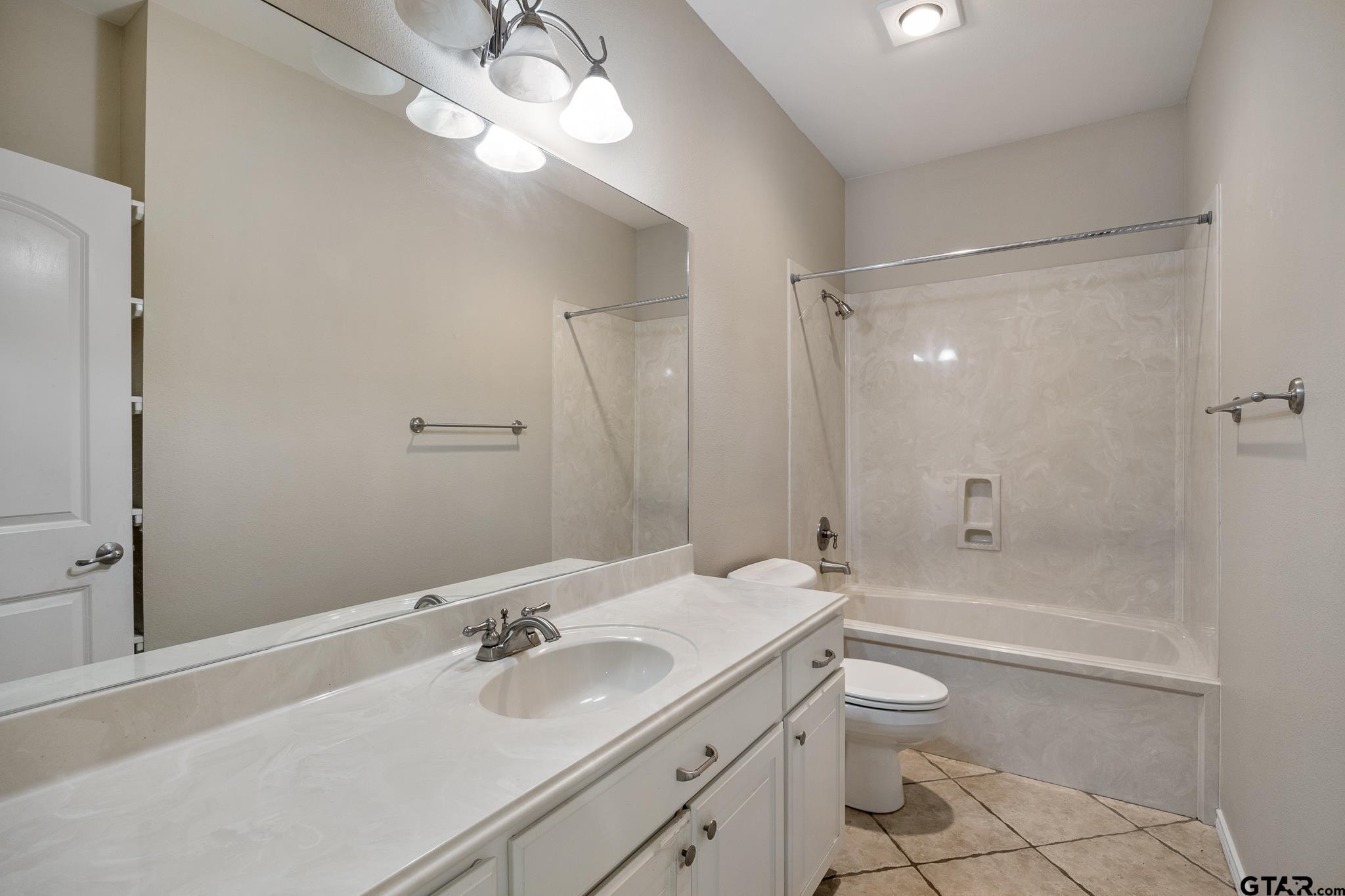 5603 Thomas Nelson Drive Tyler, TX 75707 - Photo 19 of 28 a bathroom with a sink a toilet and shower
