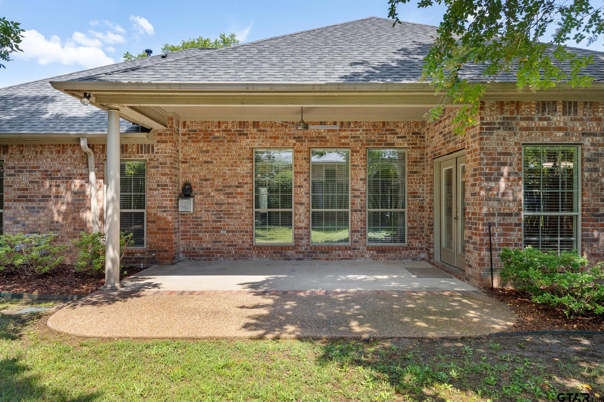 5603 Thomas Nelson Drive Tyler, TX 75707 - Photo 21 of 28 a view of backyard with brick wall and potted plants