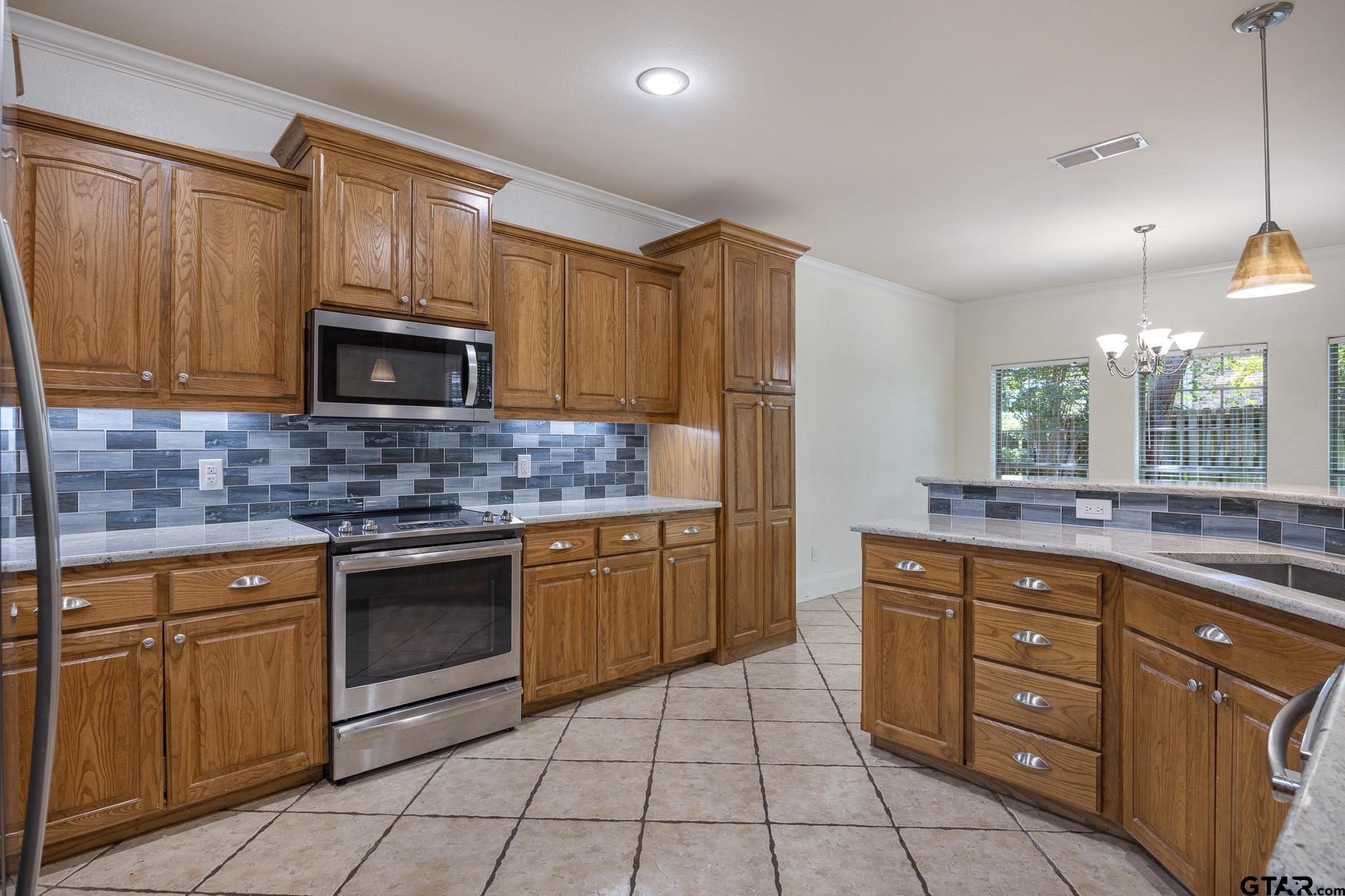 5603 Thomas Nelson Drive Tyler, TX 75707 - Photo 6 of 28 a kitchen with stainless steel appliances granite countertop a sink and cabinets