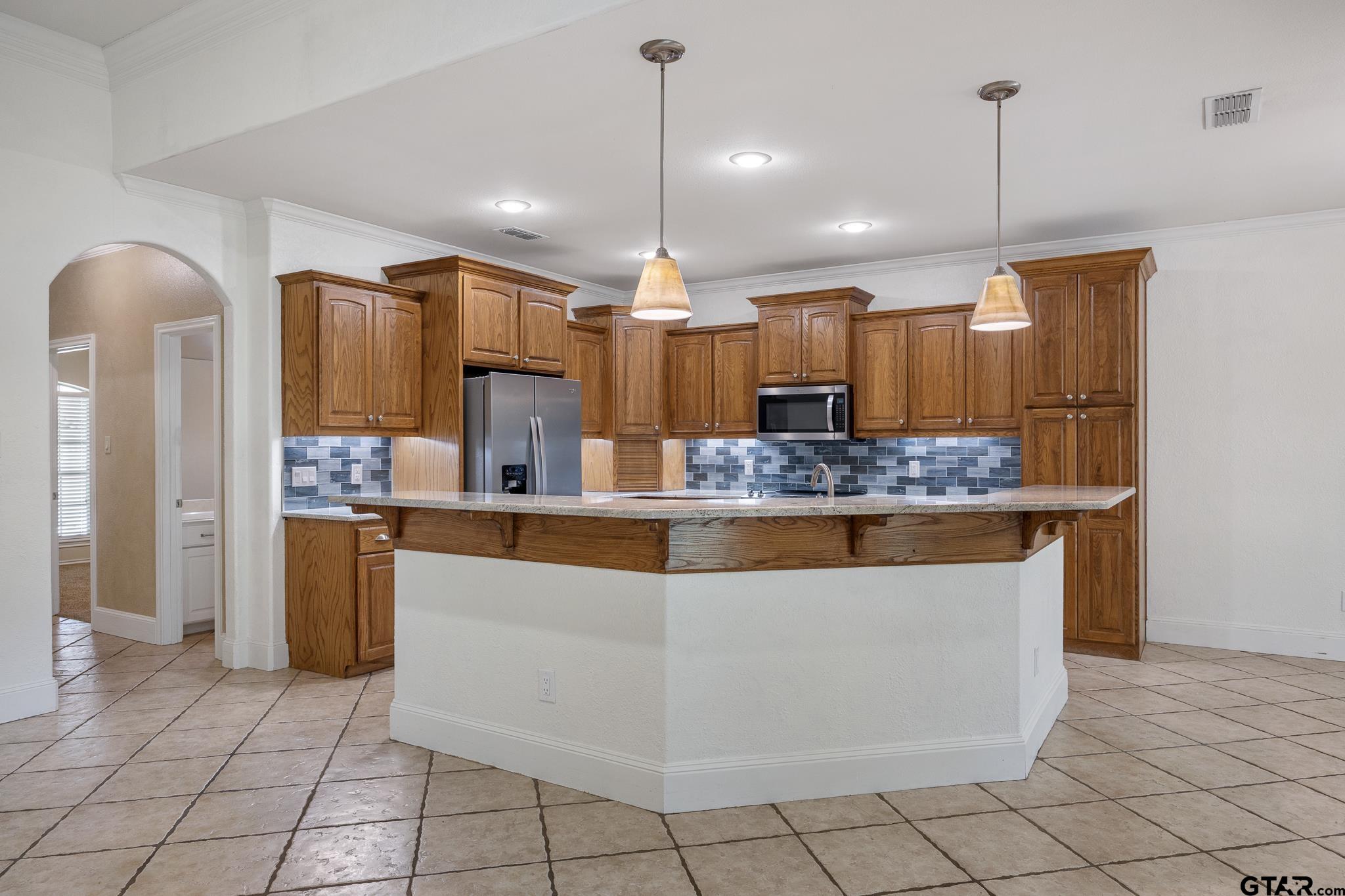 5603 Thomas Nelson Drive Tyler, TX 75707 - Photo 7 of 28 a view of kitchen with granite countertop cabinets and refrigerator