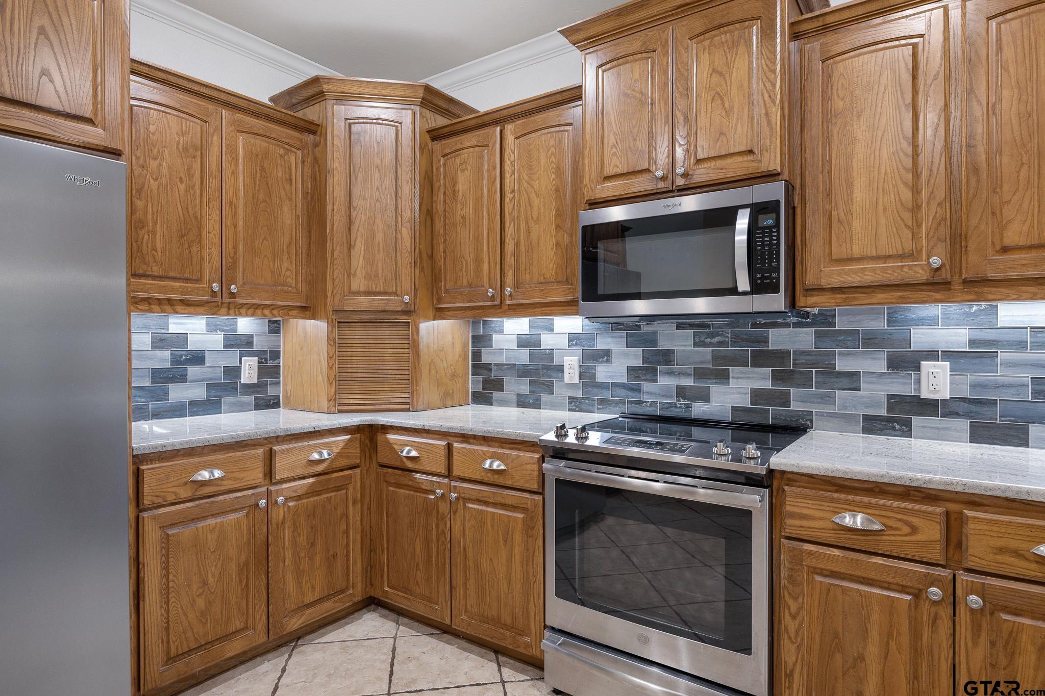 5603 Thomas Nelson Drive Tyler, TX 75707 - Photo 8 of 28 a kitchen with granite countertop cabinets stainless steel appliances and a window