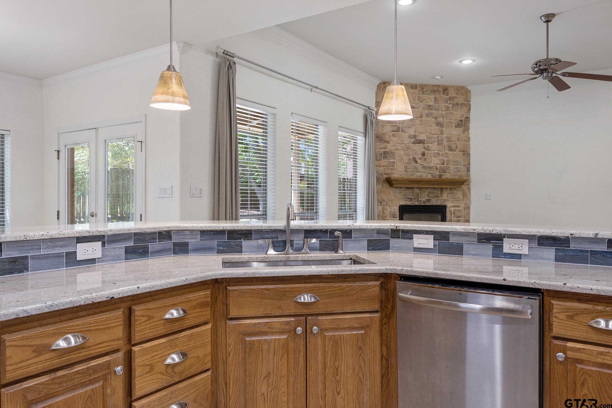 5603 Thomas Nelson Drive Tyler, TX 75707 - Photo 9 of 28 a kitchen with granite countertop a sink stainless steel appliances white cabinets and a granite counter tops