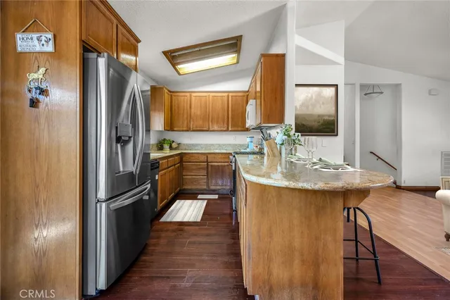 a kitchen with stainless steel appliances granite countertop a refrigerator and a sink