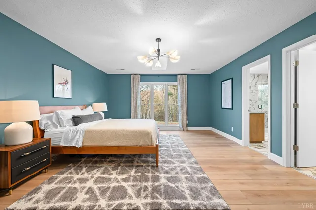 a bedroom with a large bed and a chandelier