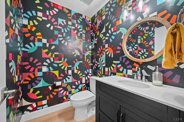 a view of house with a big yard and large trees