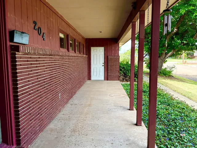 a view of a house with backyard and trees