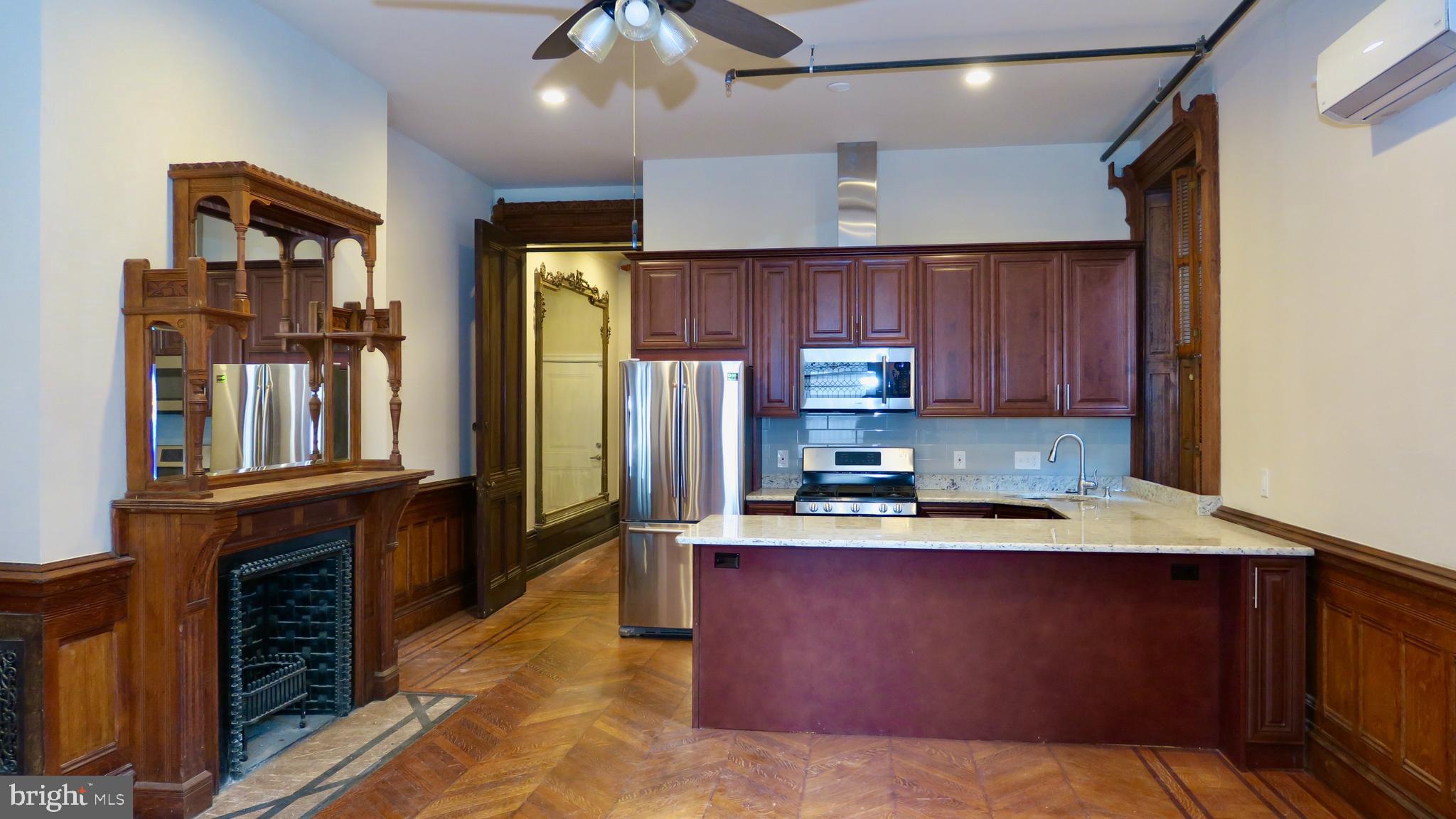 a kitchen with kitchen island granite countertop a stove refrigerator and cabinets