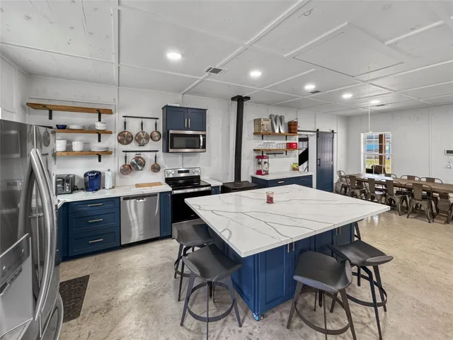 a large bedroom with bed couches and a flat tv screen