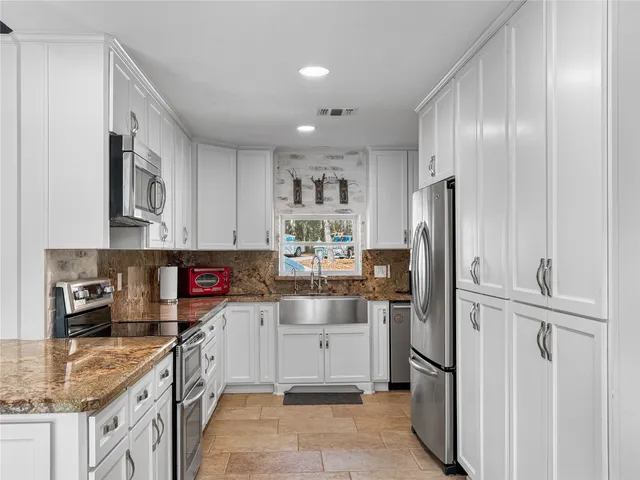 a kitchen with stainless steel appliances granite countertop a refrigerator and a sink