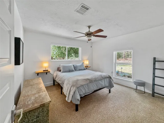 a spacious bedroom with a bed a couch and a window