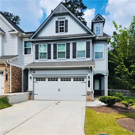 a view of a white house with large windows and a small yard
