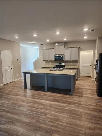 a kitchen with stainless steel appliances granite countertop a stove a sink and a refrigerator