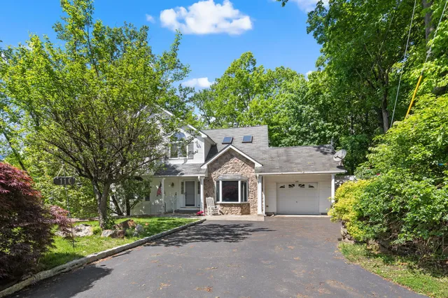front view of a house with a yard and an trees
