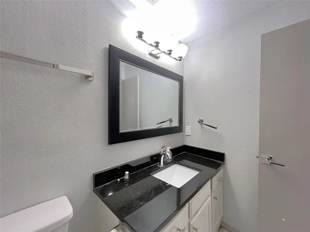 a bathroom with a sink vanity and a mirror