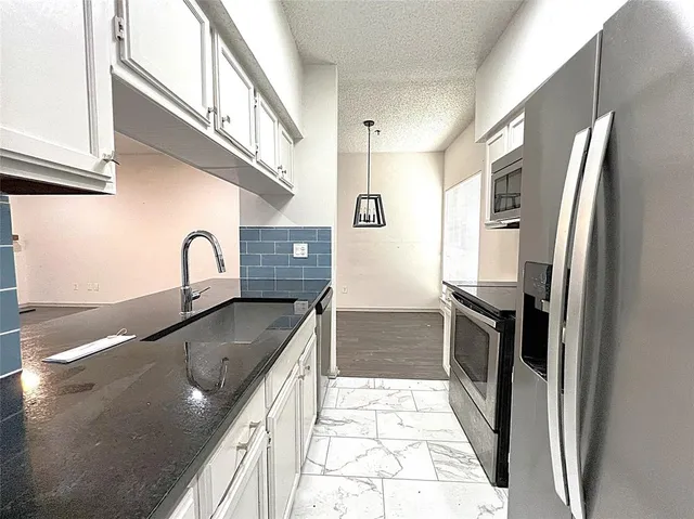 a kitchen with stainless steel appliances granite countertop a refrigerator and a sink