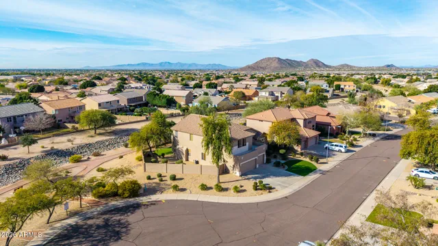 an aerial view of residential houses with outdoor space and trees