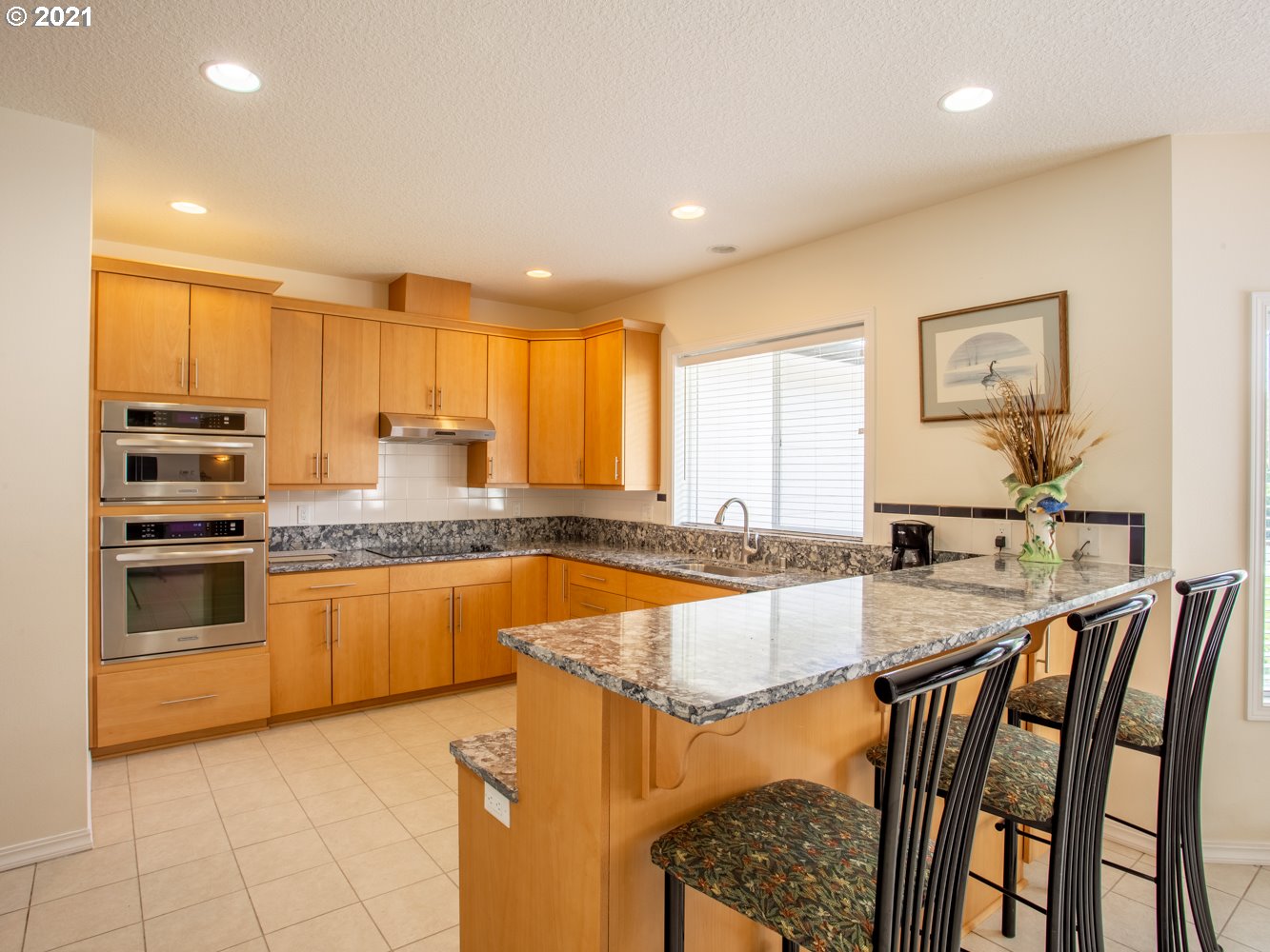 18509 Northeast Risto Road Battle Ground, WA 98604 - Photo 6 of 32 a large kitchen with kitchen island granite countertop a stove a sink a dining table and chairs