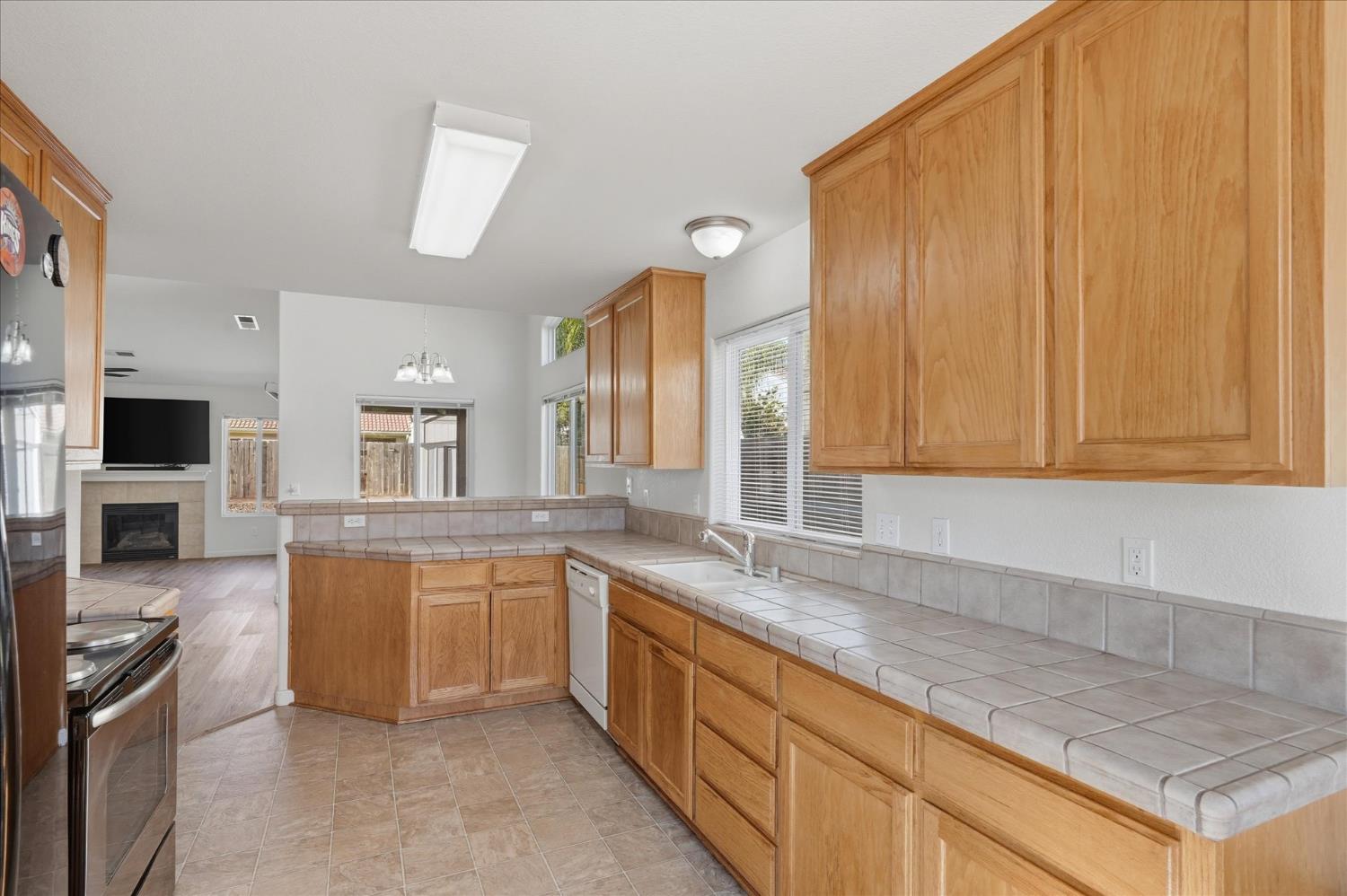 988 Monterey Street Madera, CA 93637 - Photo 12 of 36 a large kitchen with cabinets and wooden floor
