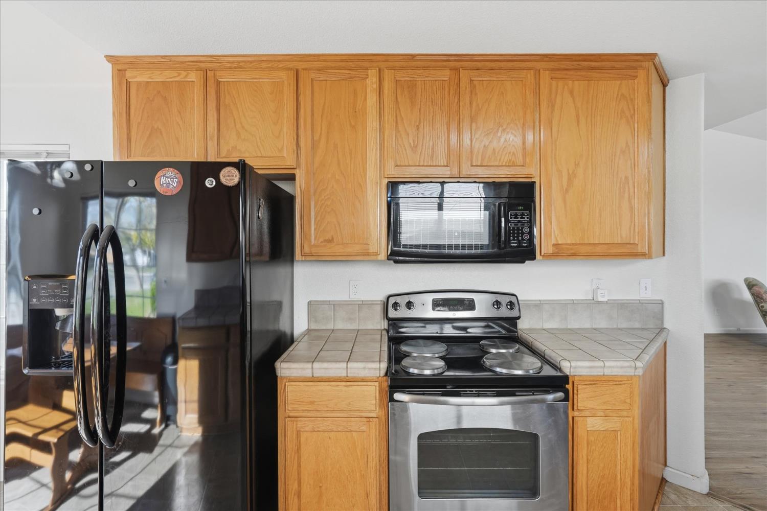 988 Monterey Street Madera, CA 93637 - Photo 13 of 36 a kitchen with stainless steel appliances granite countertop a stove a sink and a microwave