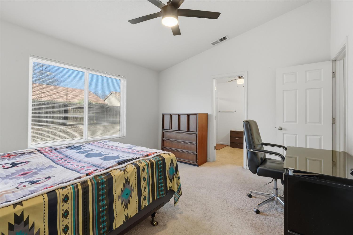 988 Monterey Street Madera, CA 93637 - Photo 17 of 36 a bedroom with a bed a desk and large window