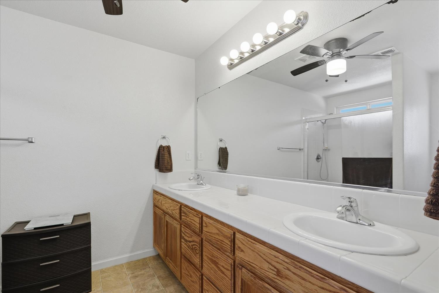 988 Monterey Street Madera, CA 93637 - Photo 19 of 36 a bathroom with a double vanity sink and a mirror