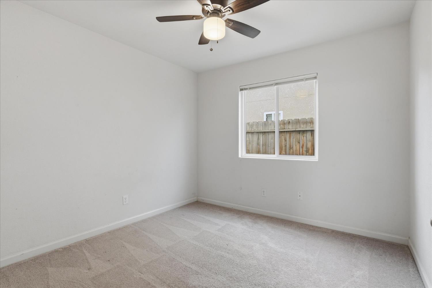 988 Monterey Street Madera, CA 93637 - Photo 23 of 36 an empty room with a window and a fan