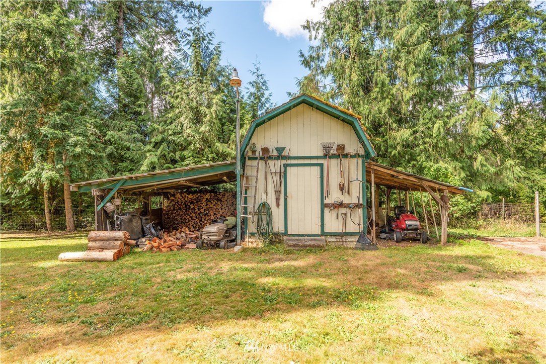 115 Island Road Toledo, WA 98591 - Photo 8 of 22 a view of a wooden house with large trees and outdoor seating