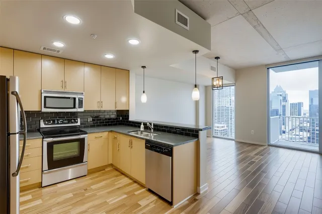 a kitchen with granite countertop a stove a sink and a refrigerator